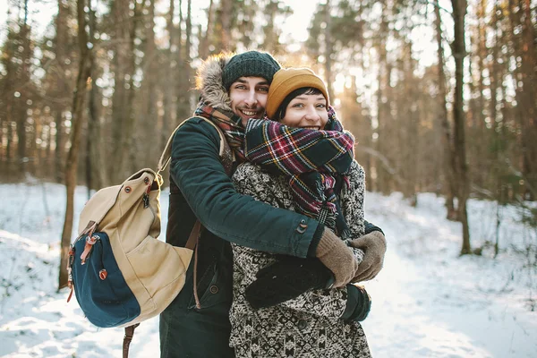 Jonge man hugs zijn vriendin in winter forest — Stockfoto