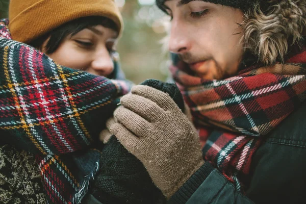 Jeune homme tient ses copines mains dans la forêt d'hiver — Photo