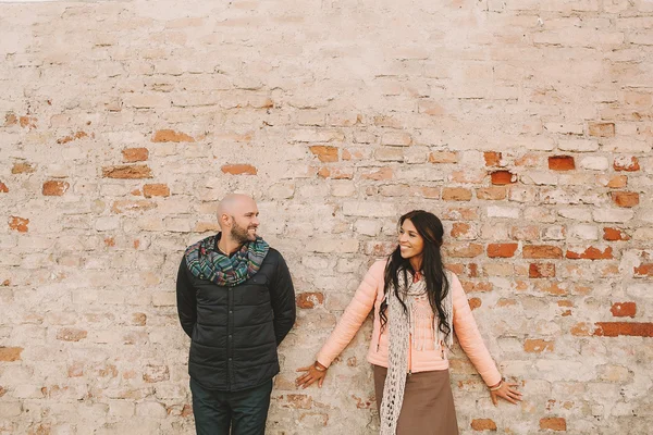 Young couple posing near the brick wall in the city — Stock Photo, Image