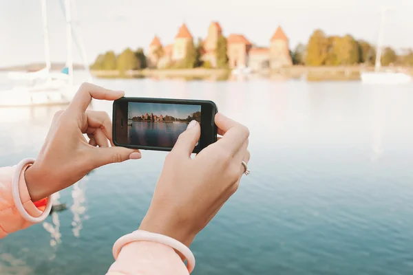 Las manos de la mujer con el teléfono tomando la foto del lugar histórico — Foto de Stock