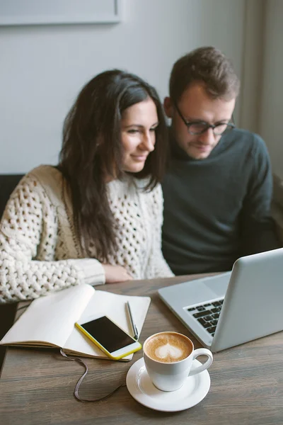 Пара работающих в кафе с ноутбуком, смартфоном и кофе — стоковое фото