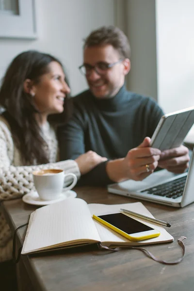 Pasangan yang bekerja di kafe dengan tablet, laptop, smartphone, notepad — Stok Foto