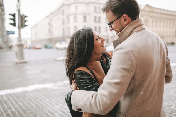 Pareja joven abrazándose en la calle de la ciudad en invierno —  Fotos de Stock