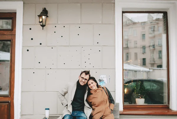 Pareja joven sentada al aire libre en la cafetería con taza de café — Foto de Stock