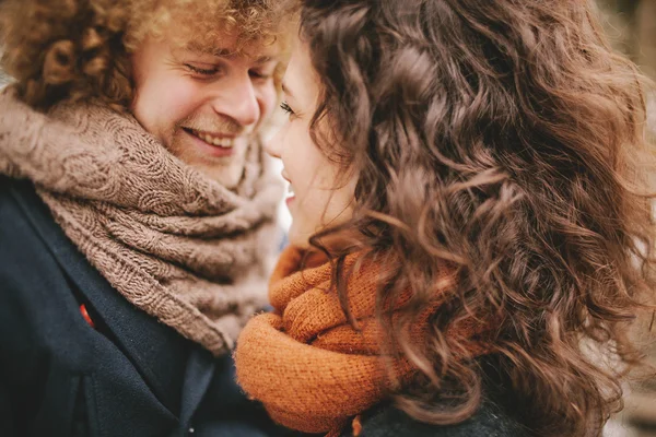 Birbirlerine gülümseyen genç kıvırcık Çift