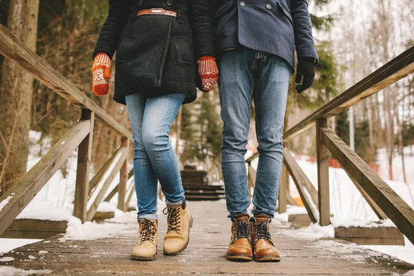 Пара тримає руки, стоячи в зимовому лісі прямо — стокове фото