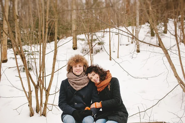 Jong koppel elkaar zitten in winter forest — Stockfoto