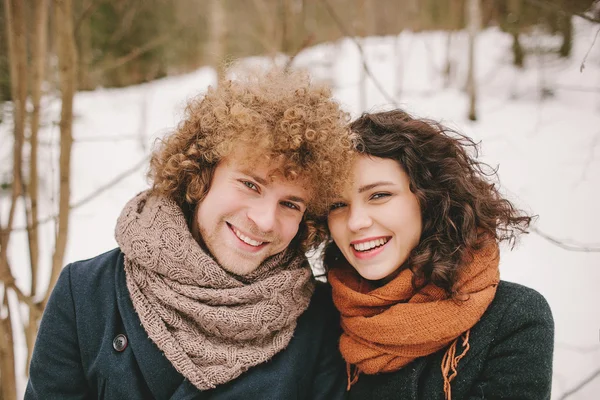 Portrait de jeune couple souriant aux cheveux bouclés en fores d'hiver — Photo