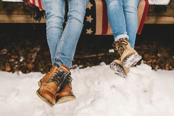 Pernas de casal em botas no chão de madeira ao ar livre — Fotografia de Stock