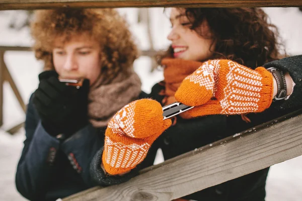 Couple jouant de l'harmonica ensemble en hiver à l'extérieur — Photo