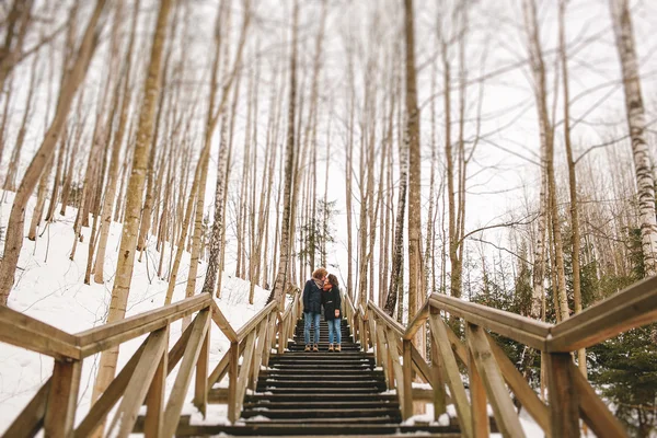 Hipster δυο φιλιά στην ξύλινη σκάλα στο χειμερινό πάρκο — Φωτογραφία Αρχείου