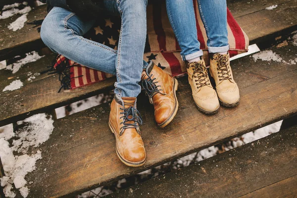 Duas pessoas sentadas no tapete de estilo americano nas escadas de madeira — Fotografia de Stock