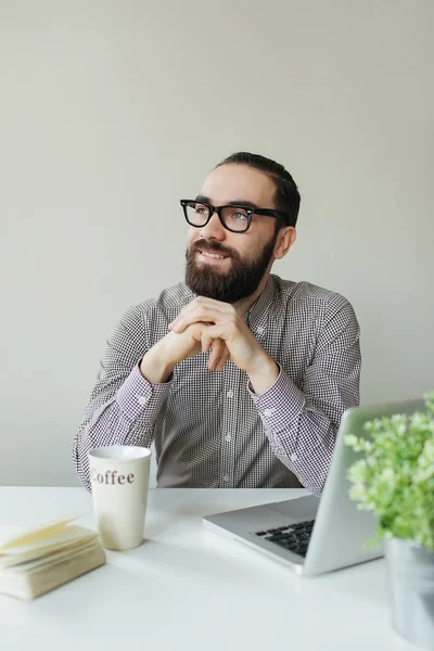 Vriendelijke man denken op hetbedrijfsleven met laptop met koffie — Stockfoto