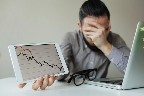 Depressed businessman leaning head below bad stock market chart — Stock Photo, Image