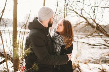 Ağaçta donmuş göl üzerinde oturan hipster Çift