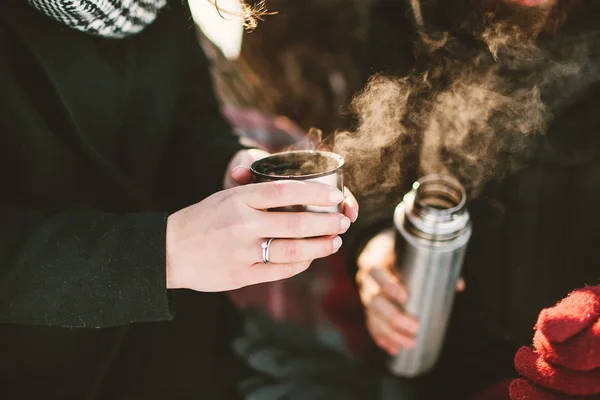 Pareja en el parque de invierno con té caliente de termos —  Fotos de Stock