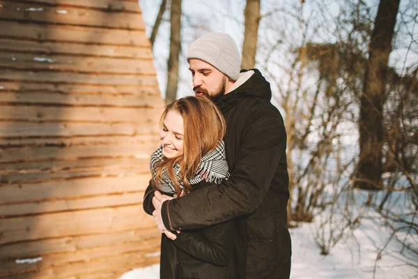 Young hipster couple hugging in winter forest — Stock Photo, Image