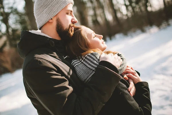 Joven pareja hipster abrazándose en el bosque de invierno —  Fotos de Stock