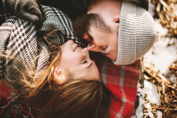 Couple close lying on plaid in winter park — Stock Photo, Image