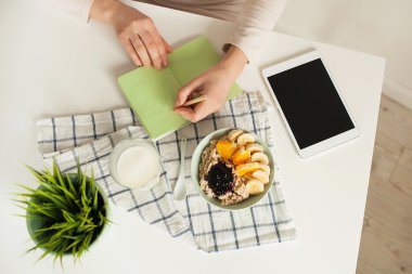 Notlar not defteri ile masasına sağlıklı yemek yapma kadın