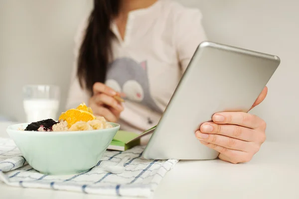 Woman making notes with tablet and healthy food on table — Stock Photo, Image