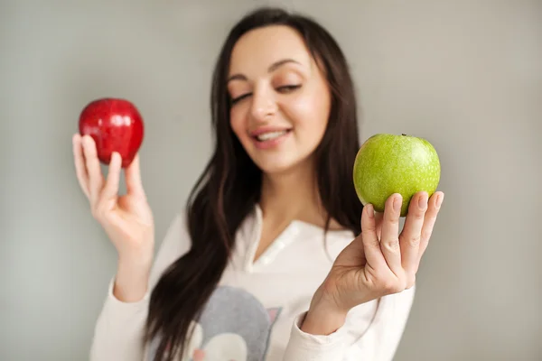 Young woman holds two apples and smiling — Stock Photo, Image