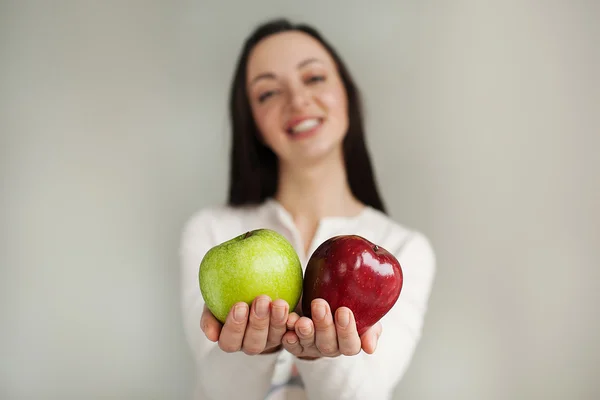 Young woman holds two apples and smiling — Stock Photo, Image