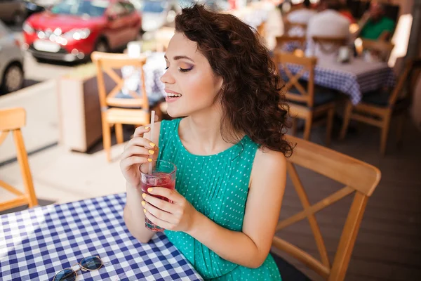 Mulher em óculos de sol redondos com coquetel no terraço do café se divertindo — Fotografia de Stock