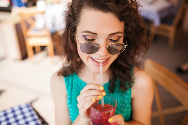 Kadın kokteyl eğleniyor Cafe teras ile yuvarlak güneş gözlüğü — Stok fotoğraf