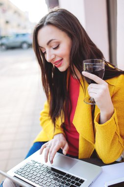Kırmızı şarap tablet ve sokak kafede dizüstü kadın ile