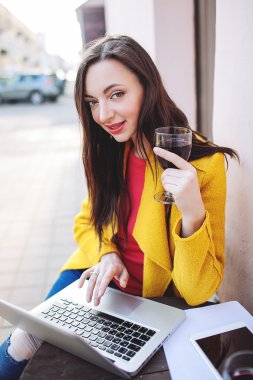 Kırmızı şarap tablet ve sokak kafede dizüstü kadın ile