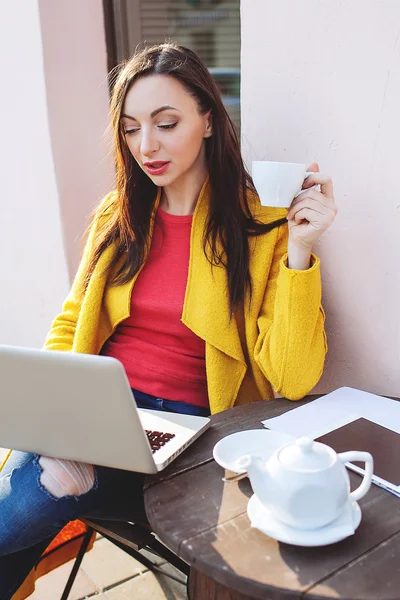 Молодая женщина с ноутбуком планшет и чай на открытом воздухе в кафе — стоковое фото