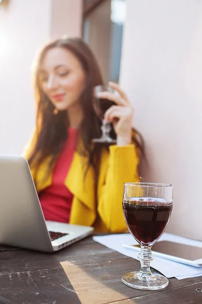 Woman with red wine tablet and laptop in street cafe — Stock Photo, Image