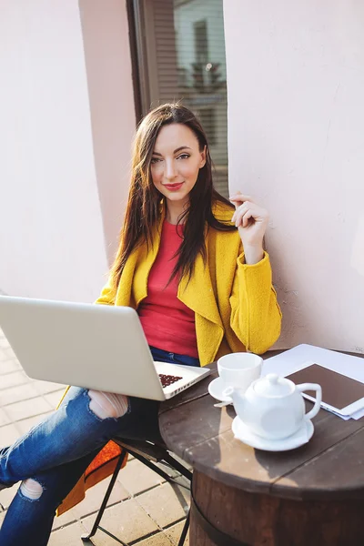 Młoda kobieta z laptopa tabletki i herbaty na zewnątrz w kawiarni — Zdjęcie stockowe