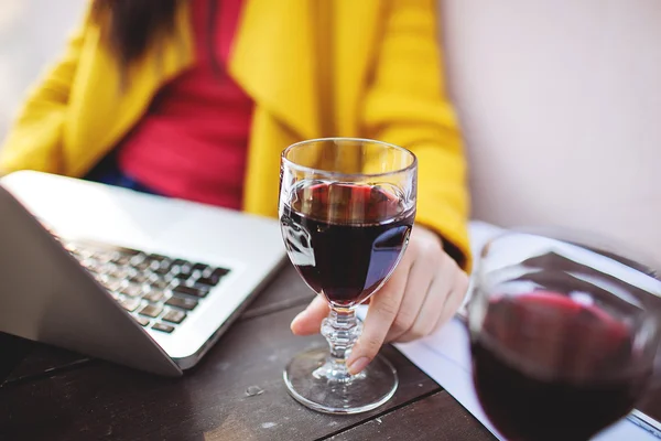 Frau hält Rotweintablett und Laptop in Straßencafé — Stockfoto