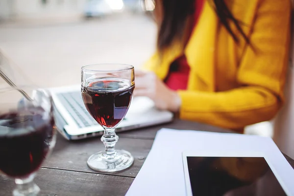 Kırmızı şarap tablet ve sokak kafede dizüstü kadın ile — Stok fotoğraf