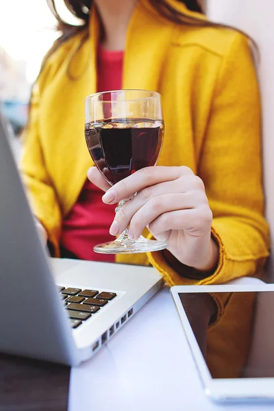 Woman with red wine tablet and laptop in street cafe — Stock Photo, Image