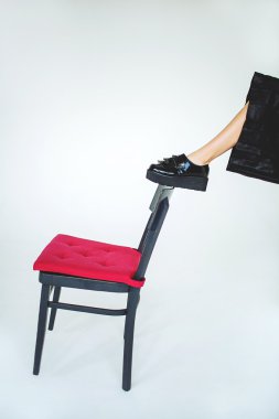 Sandalye üzerinde izole arka plan üzerinde trendy aksanlı konuşma bacağından