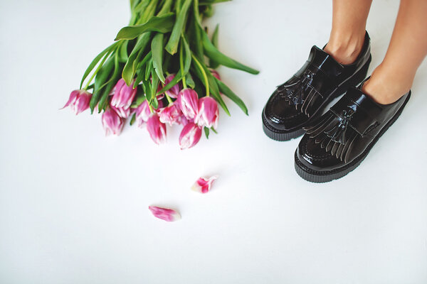 Belle spille di pelle nera alla moda sulle gambe delle donne con fiori — Foto Stock
