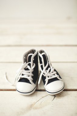 Ahşap zemin üzerinde Bebek Siyah beyaz spor ayakkabı