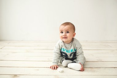 Ahşap katta oturan bir yaşındaki şirin bebek çocuk