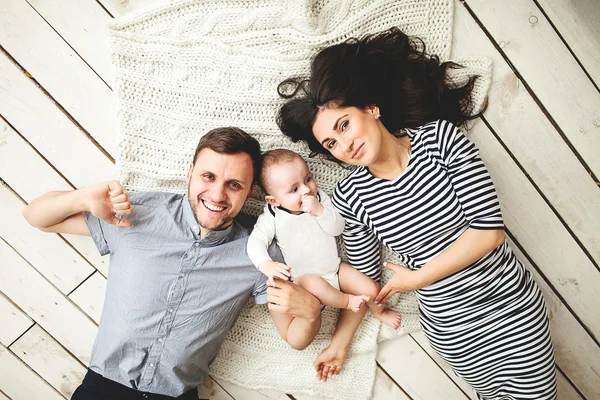 Giovane padre, madre e bambino carino sdraiato sul pavimento — Foto Stock