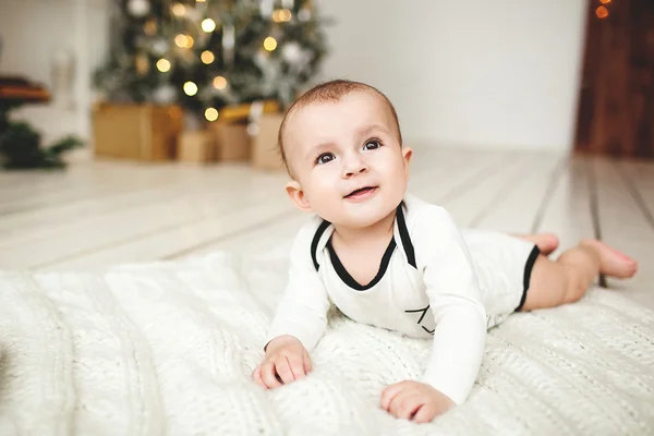 Menino na criança no chão de madeira sobre árvore de Natal — Fotografia de Stock