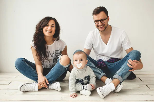 Genç hipster baba, anne ve bebek çocuk ahşap zemin üzerinde