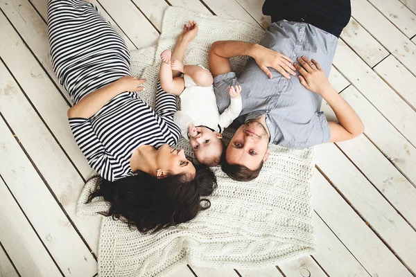 Young father, mother and cute baby lying on floor — Stock Photo, Image