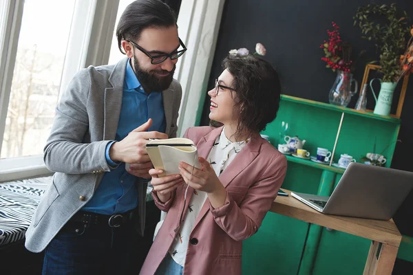 Сучасний бізнесмен в окулярах обговорює роботу з колегою по роботі — стокове фото
