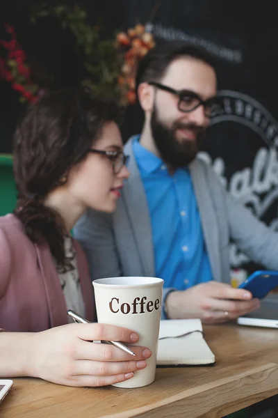 Equipo moderno que trabaja en la cafetería con el ordenador portátil, teléfono inteligente con café — Foto de Stock