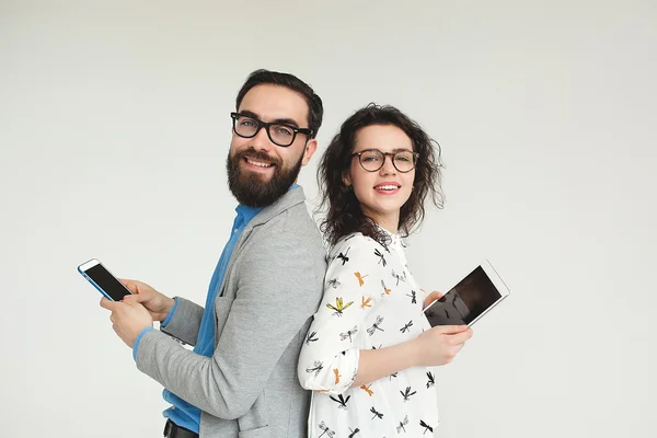 Hipster team in glasses with smartphone tablet isolated on white — Stock Photo, Image