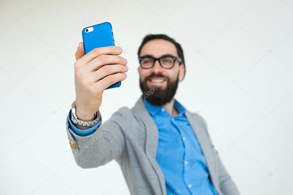 Hipster in glasses making selfie isolated on white background