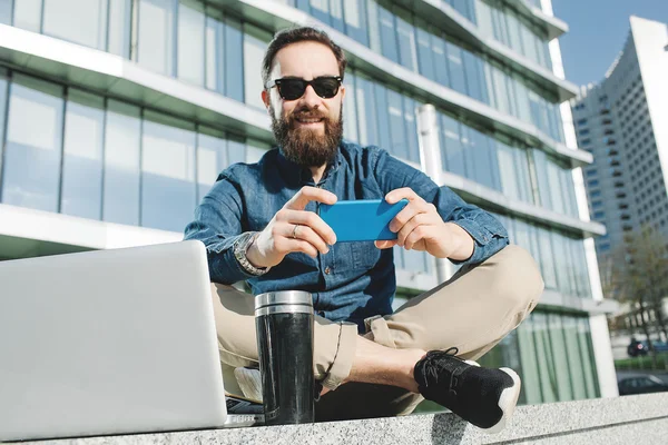 Joven hipster en gafas de sol haciendo selfie con café al aire libre —  Fotos de Stock
